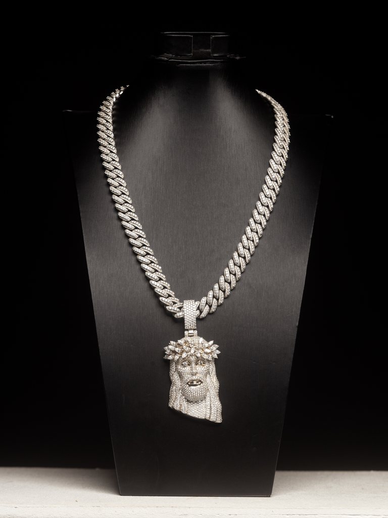 Diamond face pendant displayed on a black necklace bust.